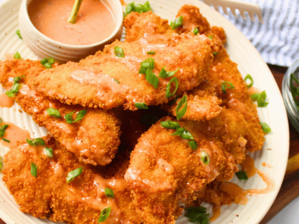 Crunchy bang bang chicken tenders drizzled with creamy spicy sauce — an easy fried chicken recipe perfect for family dinner or game day appetizer.
