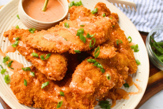 Crunchy bang bang chicken tenders drizzled with creamy spicy sauce — an easy fried chicken recipe perfect for family dinner or game day appetizer.