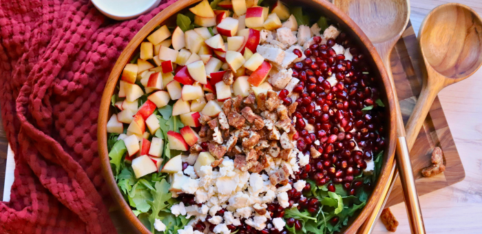 Healthy fall salad with Springer Mountain Farms Herb Poached Chicken, fresh apples, pomegranate seeds, candied pecans, and feta over arugula — easy seasonal recipe.