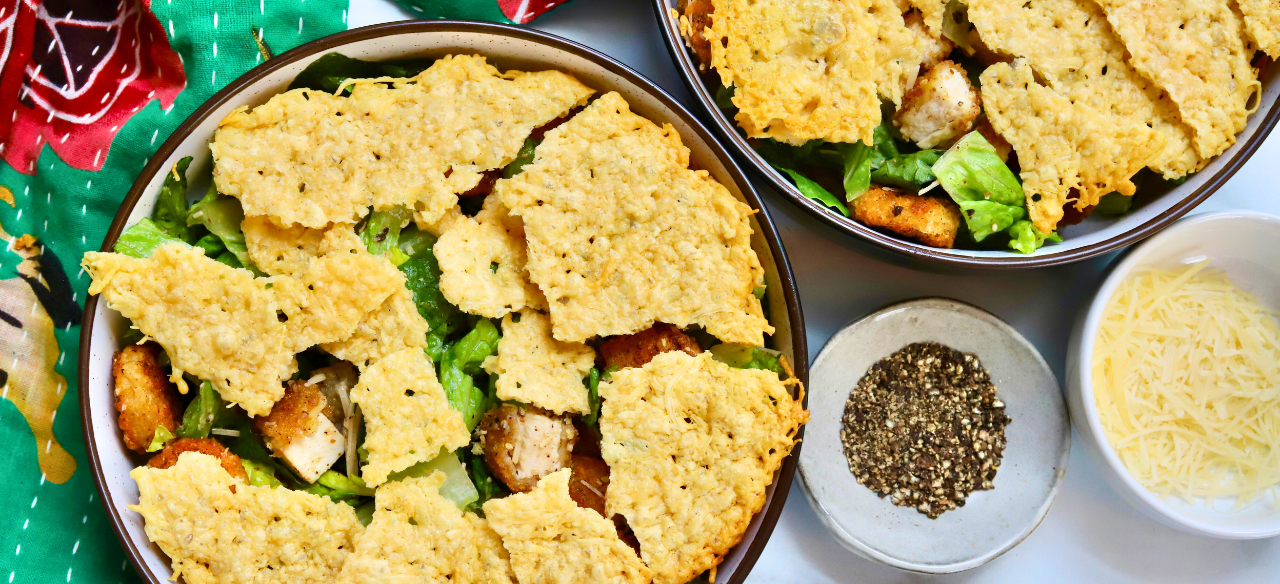 Crispy chicken Caesar salad topped with crunchy parmesan crisps and golden potatoes, served with fresh romaine and cracked black pepper.