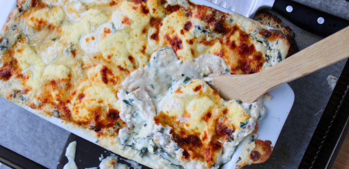 Creamy white chicken lasagna with spinach and ricotta, golden and bubbly from the oven — comforting layered pasta bake made with Springer Mountain Farms chicken.