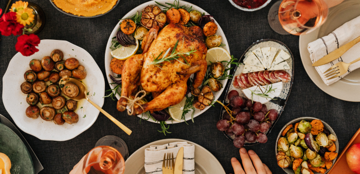 Festive holiday dinner table featuring Springer Mountain Farms roasted whole chicken with rosemary, roasted vegetables, cheese board, and seasonal sides — perfect for Thanksgiving or Christmas.