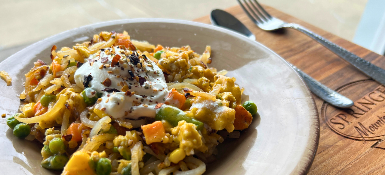 Loaded ground chicken hashbrowns with mixed vegetables, melted cheese, and a dollop of sour cream.