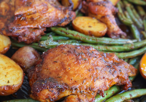 Sheet pan roasted chicken thighs with crispy baby potatoes and seasoned green beans, baked to perfection for an easy one-pan dinner"