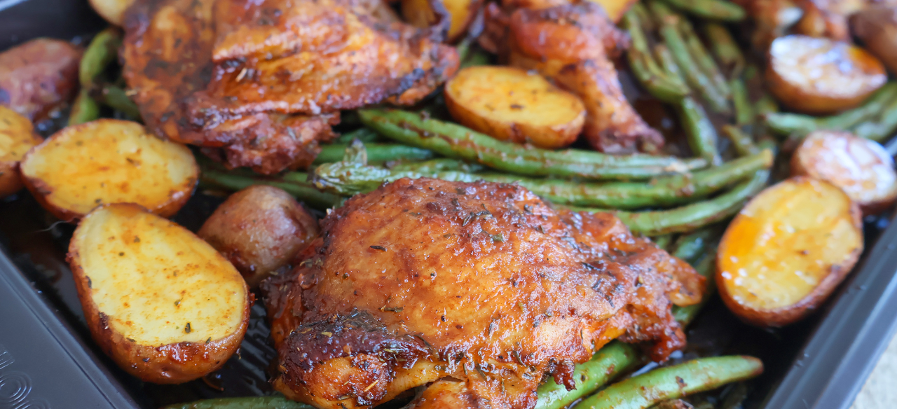 Sheet pan roasted chicken thighs with crispy baby potatoes and seasoned green beans, baked to perfection for an easy one-pan dinner"