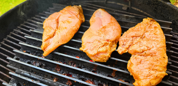 Chicken breasts placed on grill cooking first side