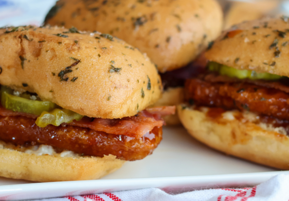 Hot honey chicken sliders with bacon, pickles and ranch made with Springer Mountain Farms fully cooked gluten free breaded chicken strip fritters.