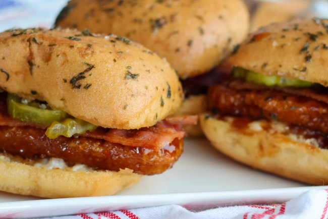 Hot honey chicken sliders with bacon, pickles and ranch made with Springer Mountain Farms fully cooked gluten free breaded chicken strip fritters.