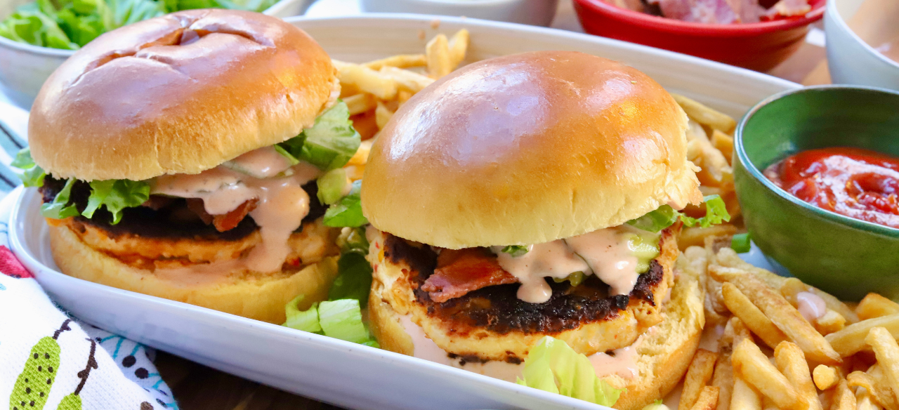 Juicy pimento cheese chicken burgers with bacon, lettuce, and spicy ranch on brioche buns served with fries