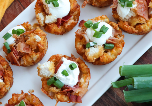 Loaded chicken bacon tater tot cups topped with sour cream and green onions