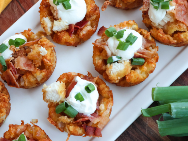 Loaded chicken bacon tater tot cups topped with sour cream and green onions