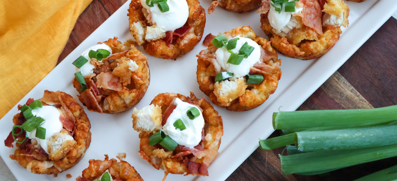 Loaded chicken bacon tater tot cups topped with sour cream and green onions